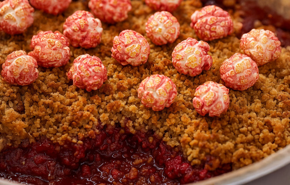 Recipe for Raspberry Pop Yum Crumble topped with colourful popcorn balls and a golden crumble crust.