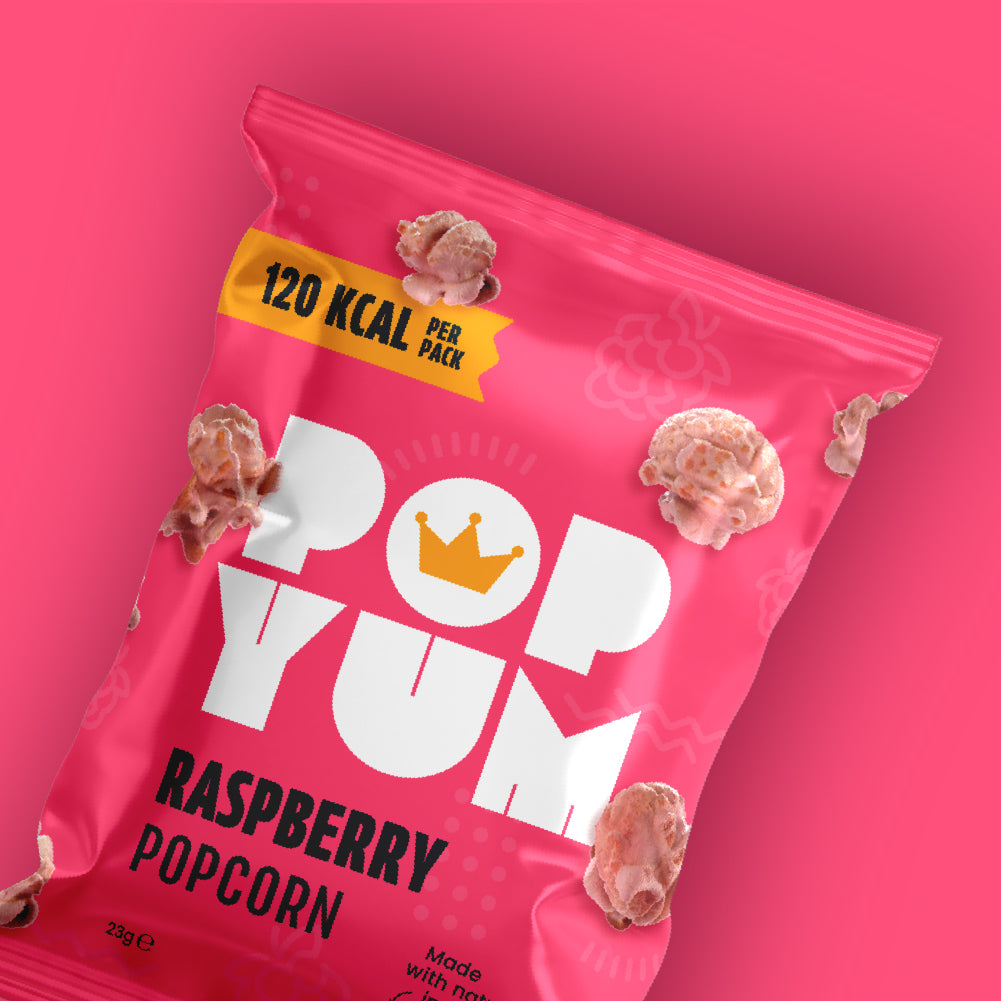 Pink package of Pop Yum Raspberry gluten-free popcorn on a pink background, 120 kcal per pack is also displayed.
