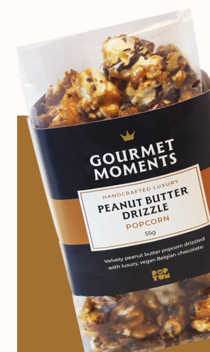 Packaged Gourmet Moments Peanut Butter Drizzle popcorn on a white background.
