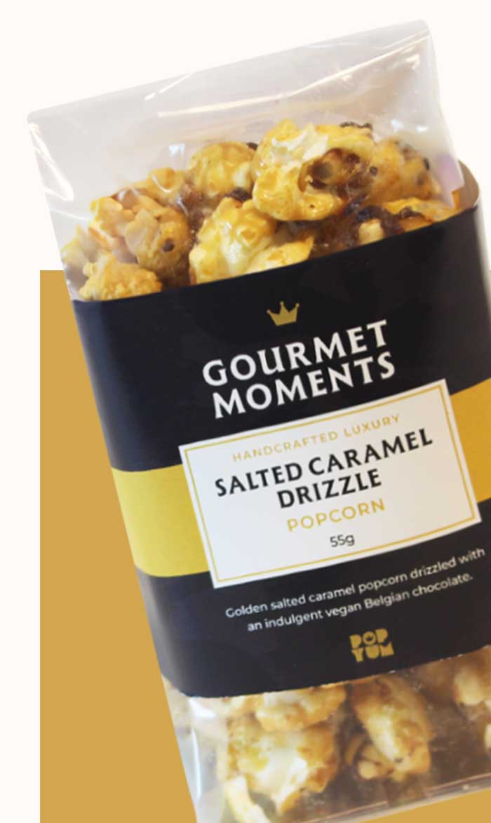 Packaged Gourmet Moments Salted Caramel Drizzle popcorn on a gold background.