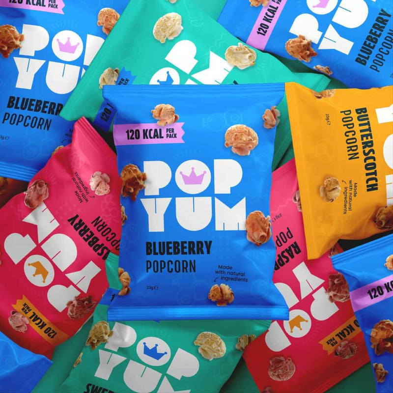 Colourful packaging of Pop Yum gluten-free, healthy vegan popcorn with various flavours on a multicoloured background.