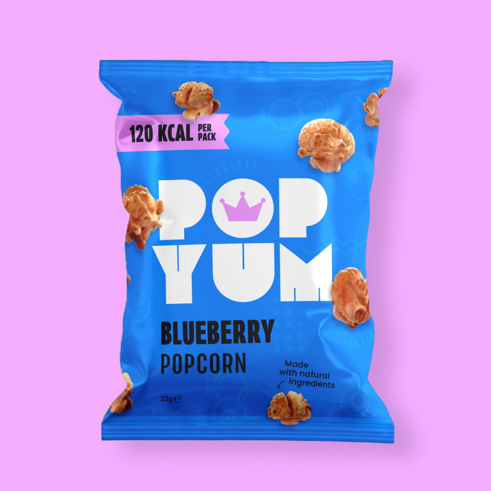 Blue package of Pop Yum blueberry-flavoured vegan popcorn on a pink background.
